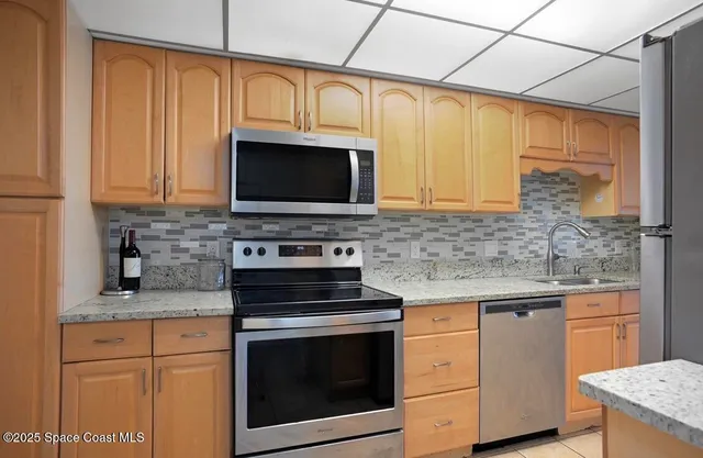 a kitchen with stainless steel appliances granite countertop a sink stove and cabinets