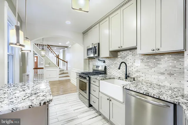 a kitchen with stainless steel appliances granite countertop a sink stove and cabinets