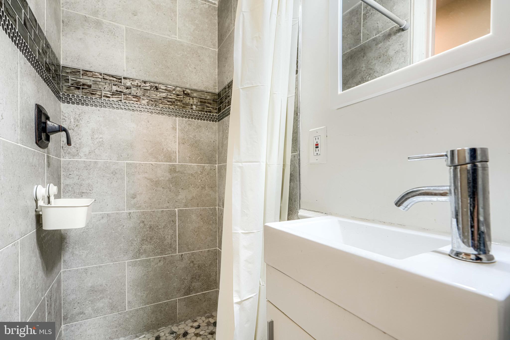 3533 Keswick Road Baltimore, MD 21211 - Photo 26 of 29 Sleek modern bathroom with elegant tiles.