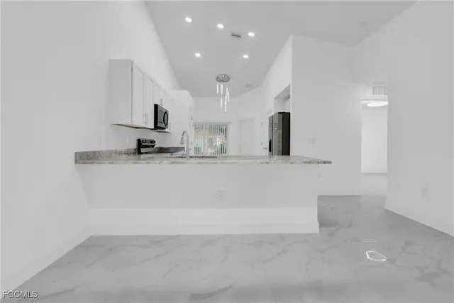 a kitchen with white cabinets and stainless steel appliances