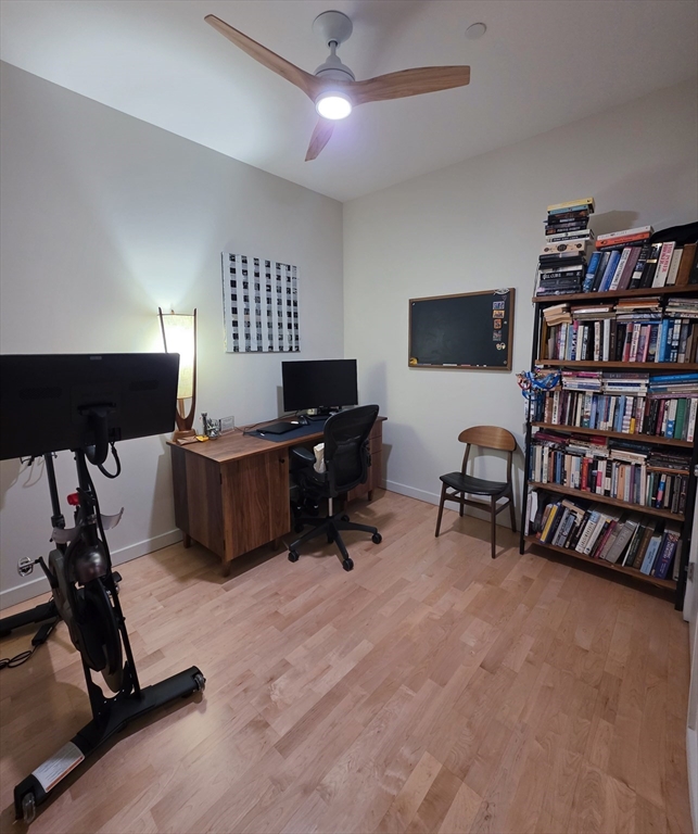 346-354 Congress Street, Unit 505 Boston, MA 02210 - Photo 9 of 14 a view of a workspace with furniture and a bookshelf