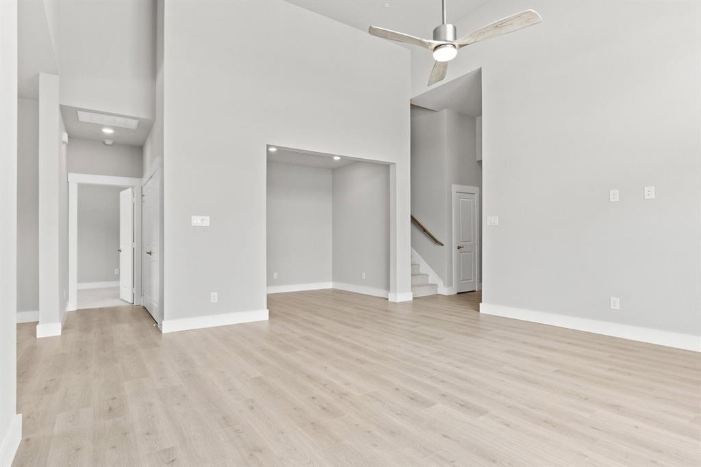 8517 Del Rio Trail Wylie, TX 75098 - Photo 7 of 30 a view of an empty room with wooden floor and a ceiling fan