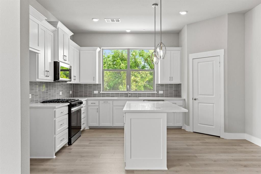 8517 Del Rio Trail Wylie, TX 75098 - Photo 10 of 30 a kitchen with stainless steel appliances granite countertop a stove a sink and a microwave