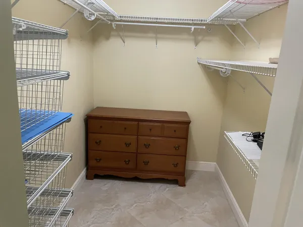an empty room with a chandelier fan and windows