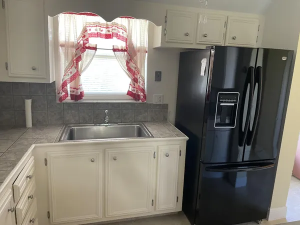 a kitchen with white cabinets and white appliances