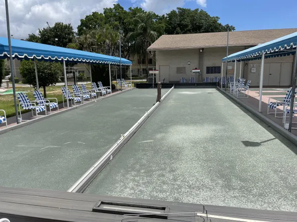 a swimming pool with lots of green space and trees in the background