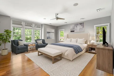 a bedroom with a large bed and windows