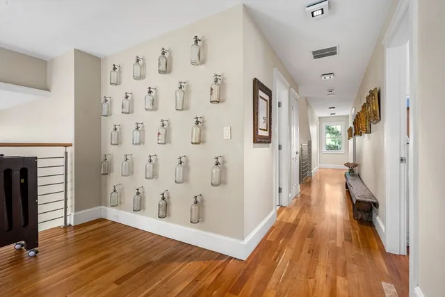 a view of a hallway with wooden floor and staircase
