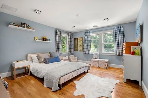 a view of a hallway with wooden floor and a rug
