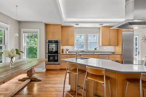 a large kitchen with kitchen island a large counter top space appliances and cabinets
