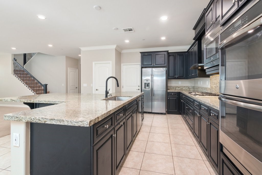 45522 Zander Court Temecula, CA 92592 - Photo 13 of 58 a kitchen with kitchen island granite countertop a sink counter top space appliances and cabinets