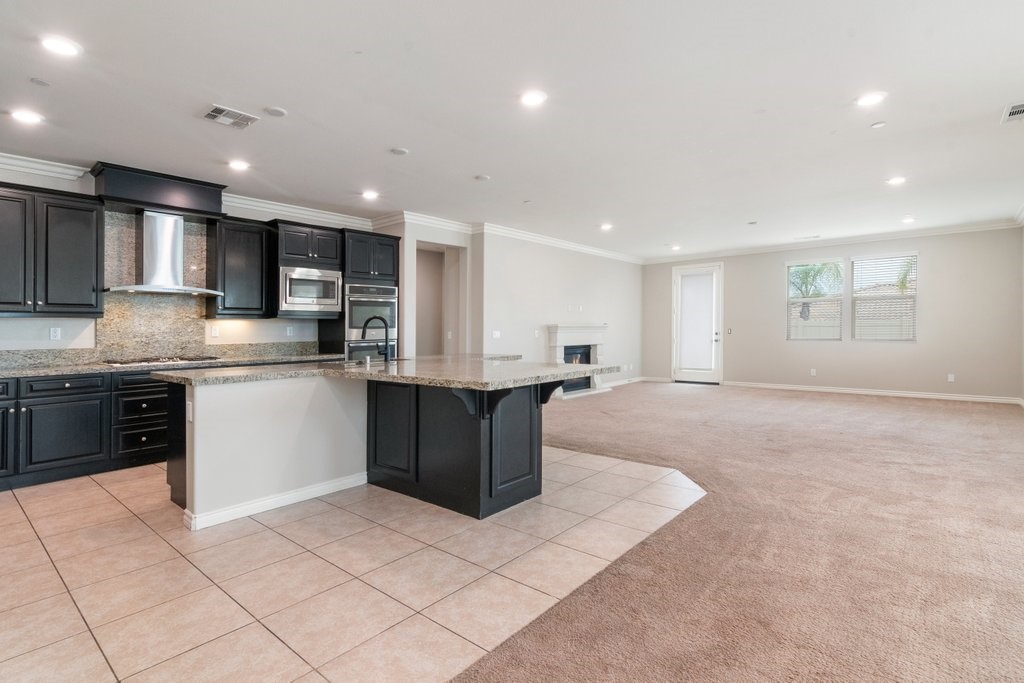 45522 Zander Court Temecula, CA 92592 - Photo 15 of 58 a kitchen with stainless steel appliances kitchen island granite countertop a sink and cabinets