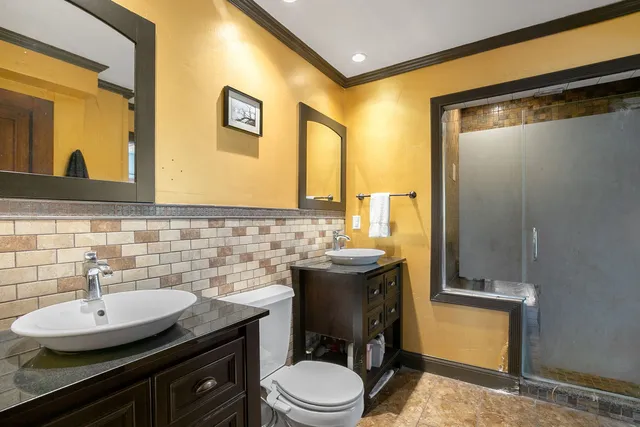 a bathroom with a granite countertop sink toilet and mirror
