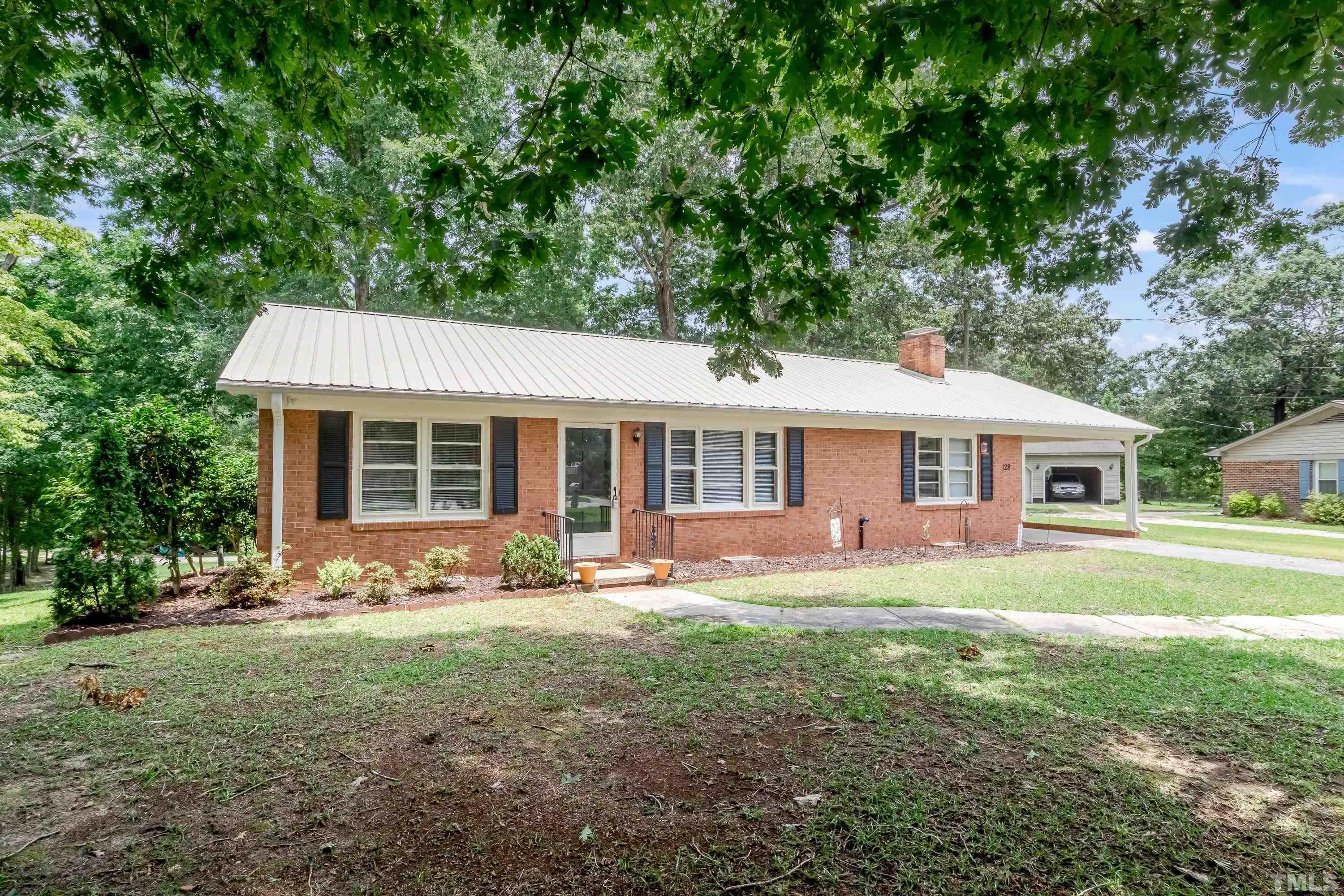 128 Spring Lane Lillington, NC 27546 - Photo 1 of 42 a front view of a house with a garden