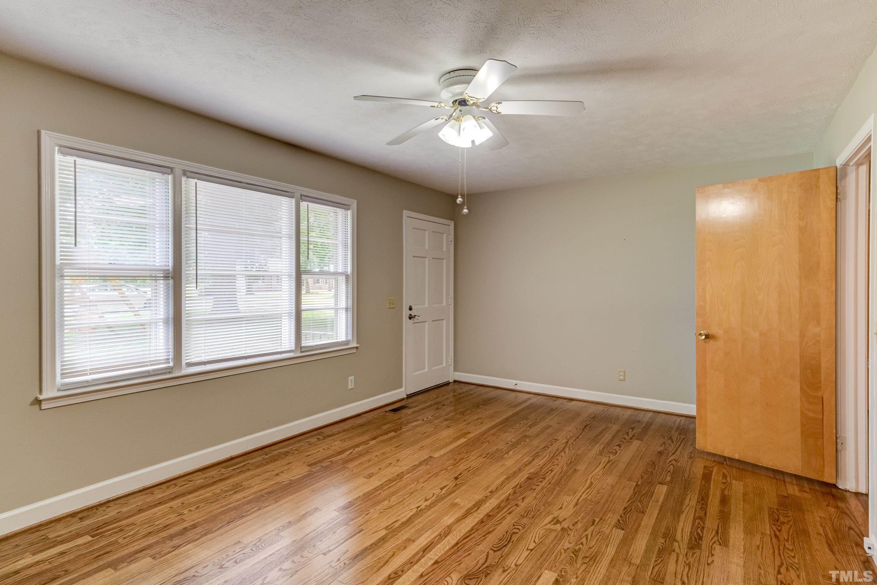 128 Spring Lane Lillington, NC 27546 - Photo 11 of 42 a view of an empty room with wooden floor and a window