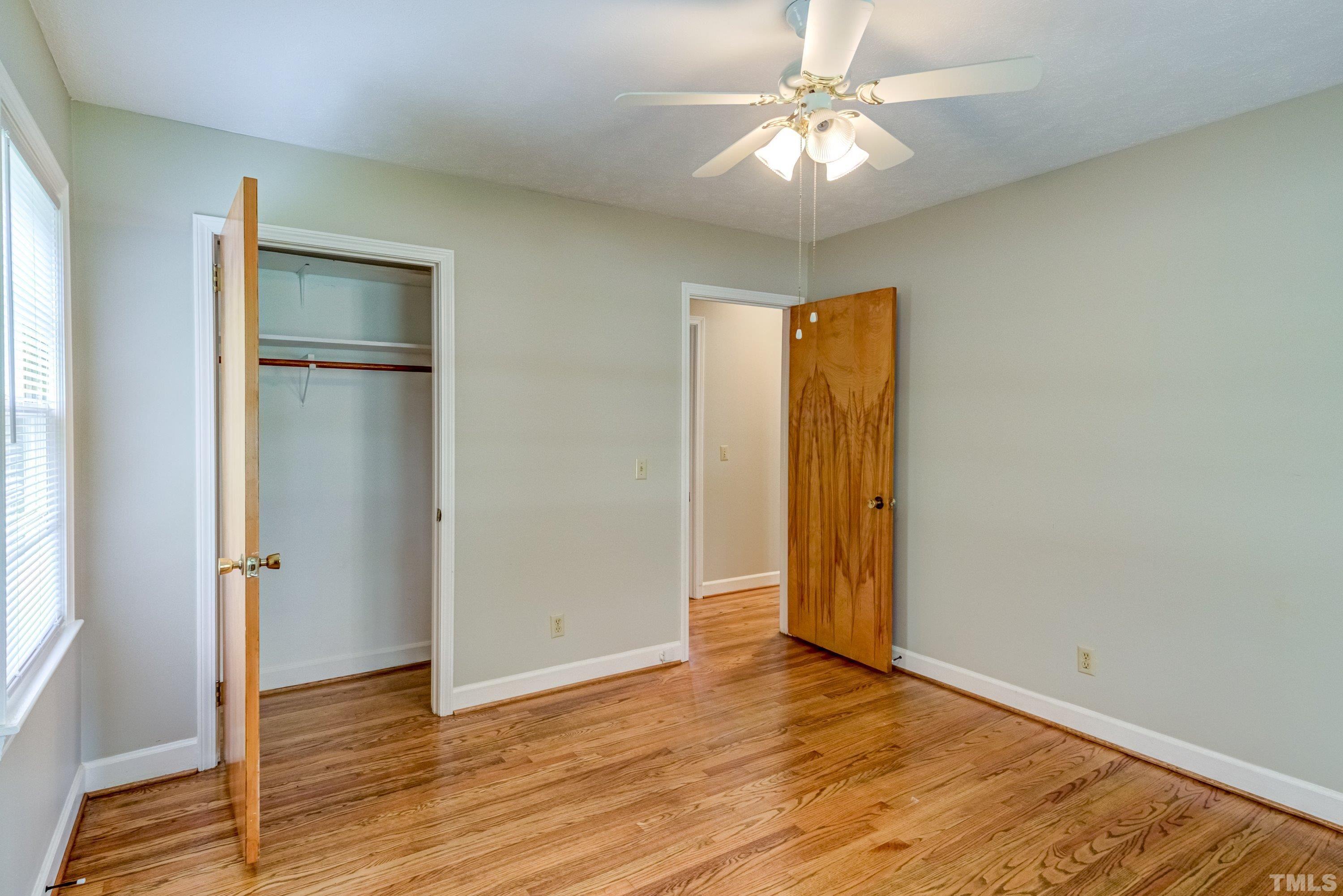 128 Spring Lane Lillington, NC 27546 - Photo 14 of 42 an empty room with wooden floor and a ceiling fan