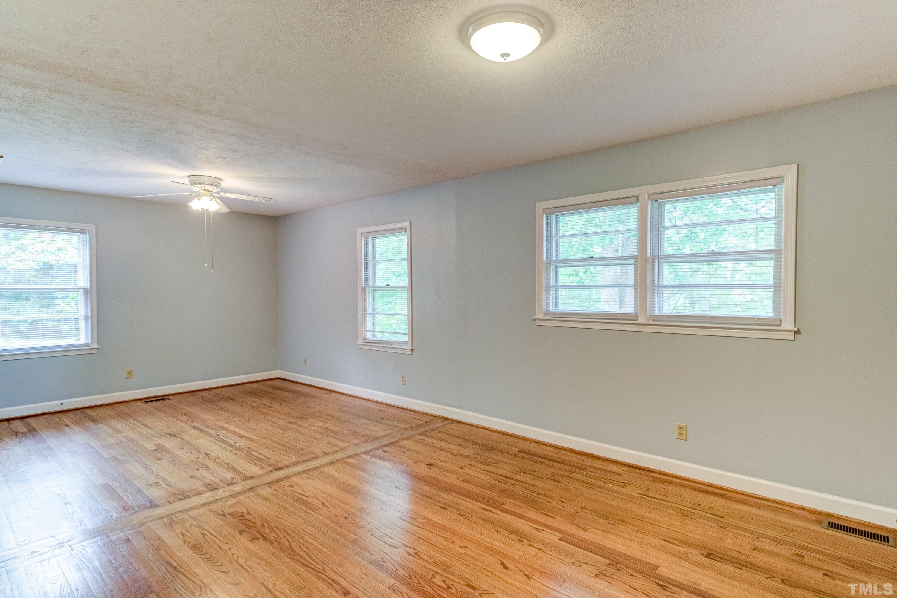 128 Spring Lane Lillington, NC 27546 - Photo 17 of 42 a view of an empty room with wooden floor and a window