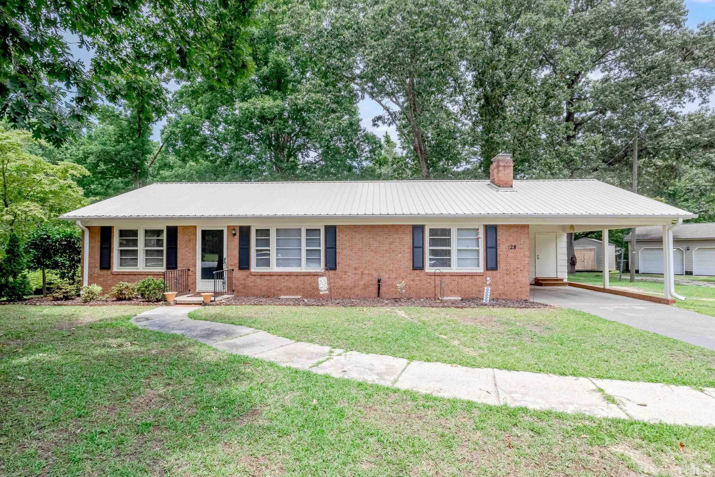 128 Spring Lane Lillington, NC 27546 - Photo 2 of 42 a front view of a house with a garden and patio