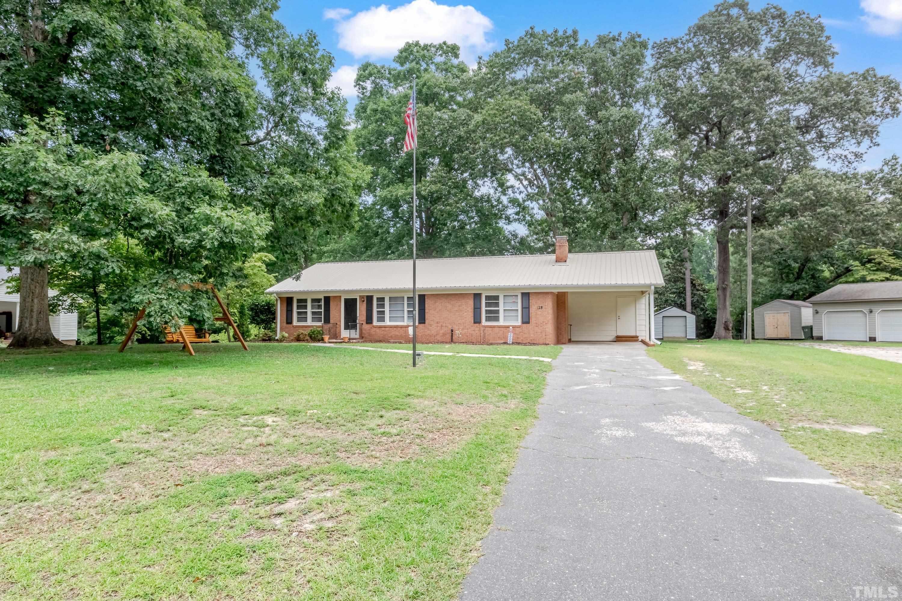 128 Spring Lane Lillington, NC 27546 - Photo 5 of 42 a view of a house next to a big yard with large trees