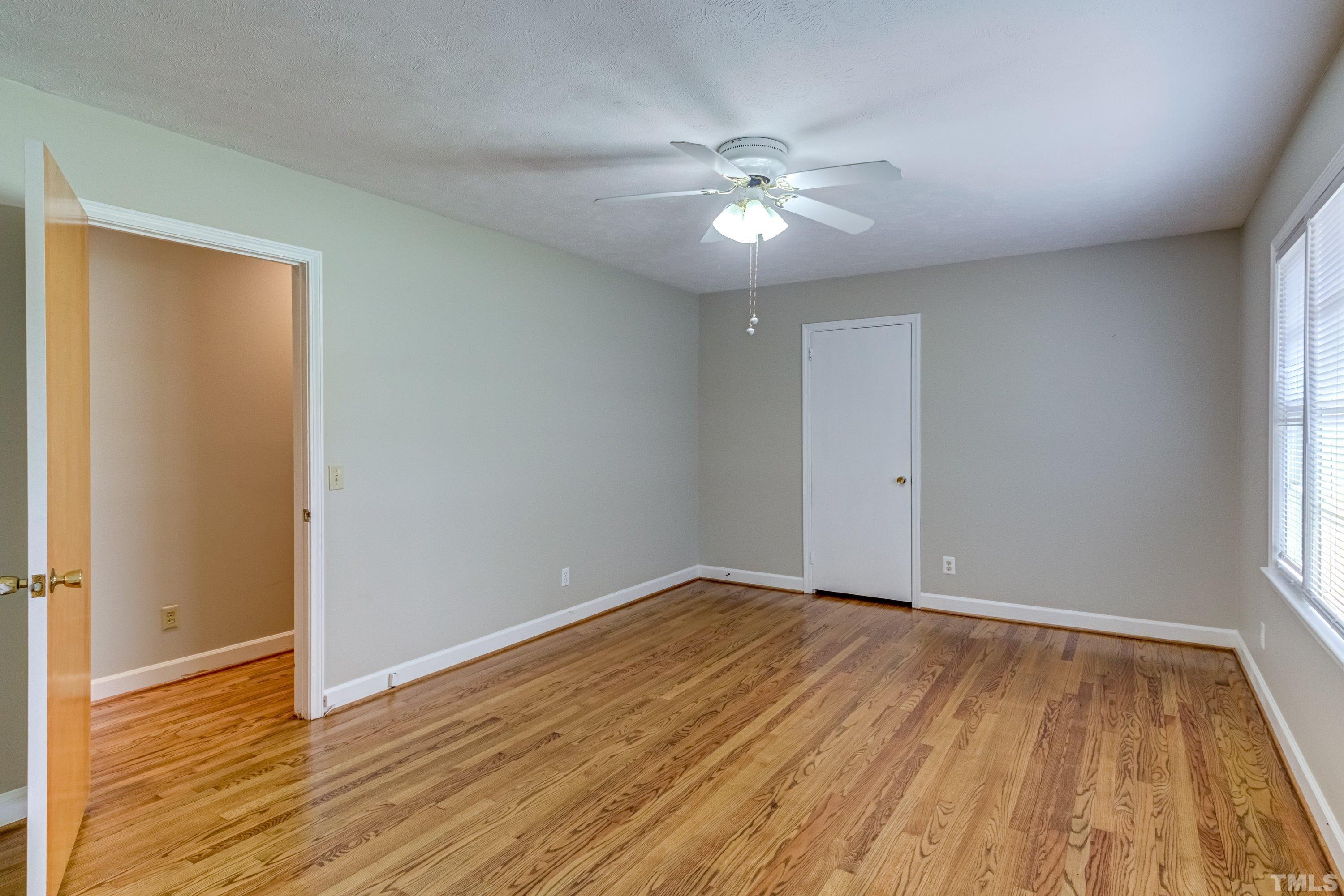 128 Spring Lane Lillington, NC 27546 - Photo 9 of 42 a view of an empty room with wooden floor and a window