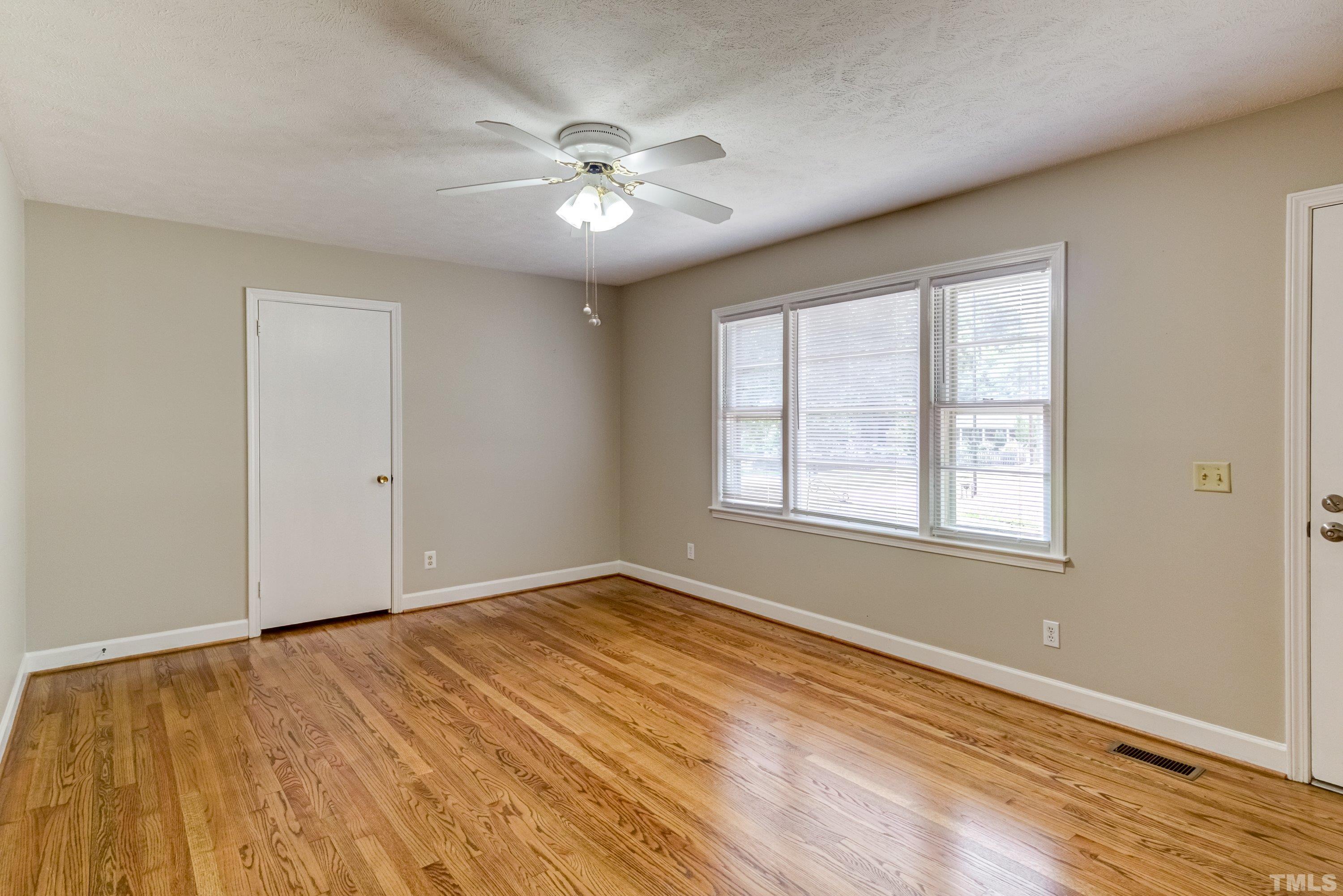 128 Spring Lane Lillington, NC 27546 - Photo 10 of 42 a view of an empty room with wooden floor and a window