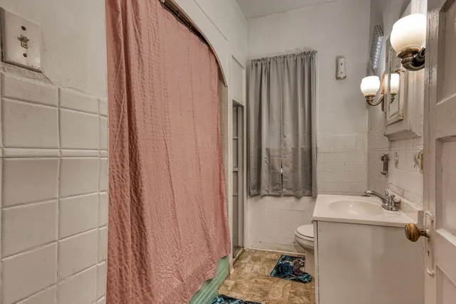 a bathroom with a sink a toilet and shower curtain
