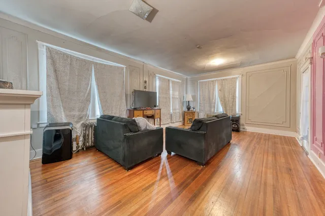 a living room with furniture and a wooden floor