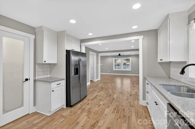 a kitchen with granite countertop a refrigerator and a sink