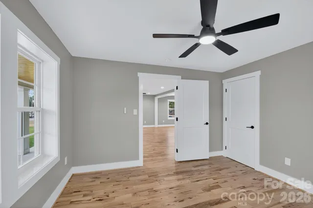 a view of empty room with wooden floor