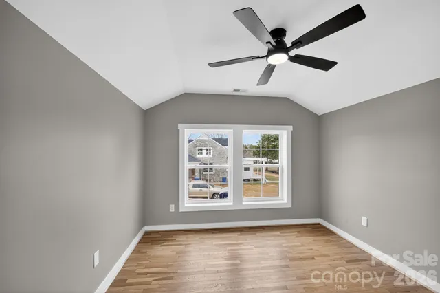 a view of an empty room with window and cabinet