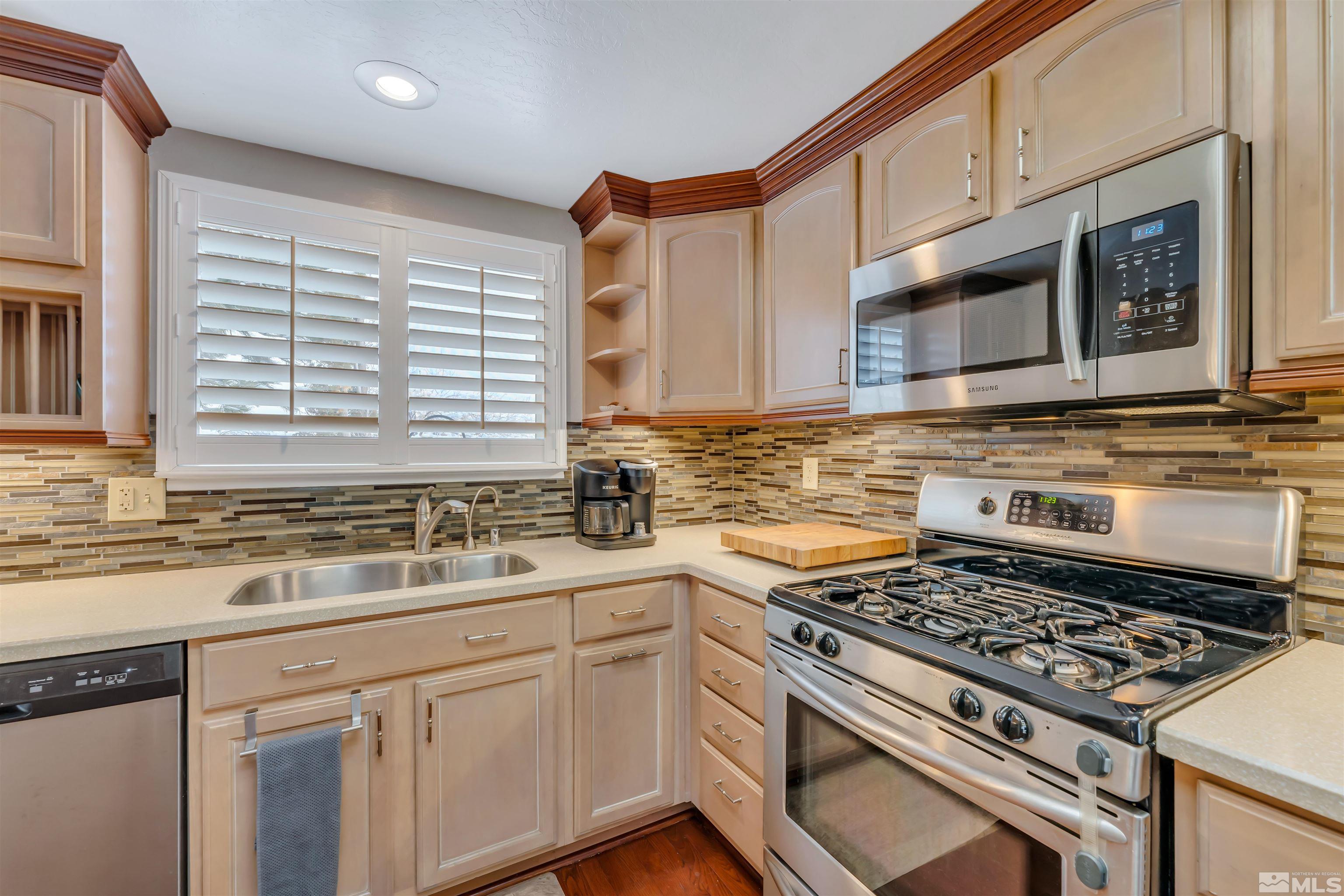 1243 Laredo Court Reno, NV 89503 - Photo 11 of 20 a kitchen with stainless steel appliances a stove a sink cabinet and a microwave