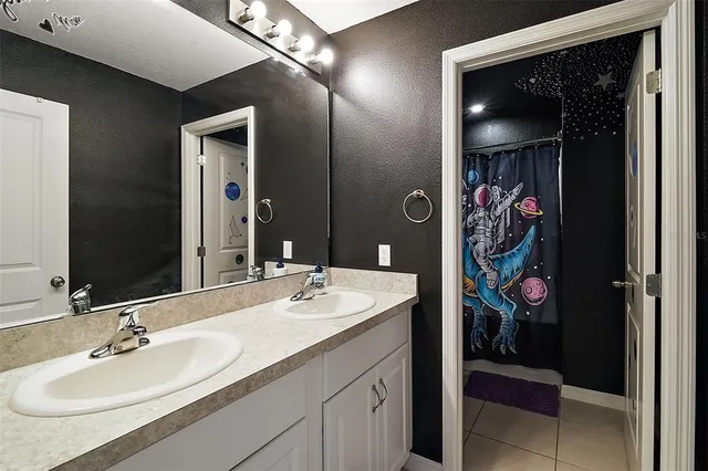 a bedroom with a bed and a flat tv screen on a dresser