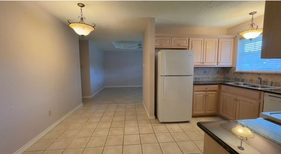 4665 Glen Oaks Circle Beaumont, TX 77708 - Photo 3 of 20 a kitchen with a refrigerator a stove top oven and cabinets
