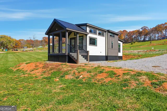 a front view of a house with a yard and ocean view