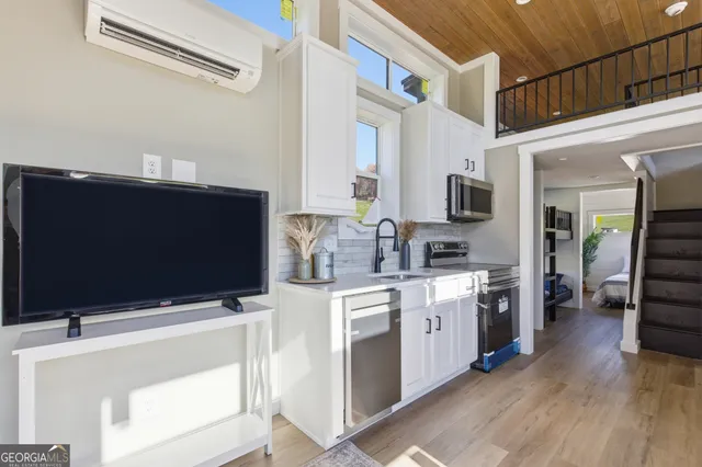 a kitchen with stainless steel appliances a stove a microwave a sink and cabinets