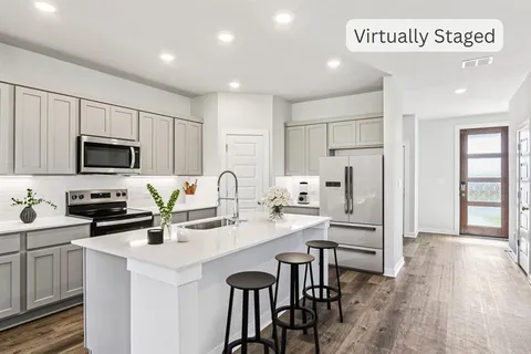 a kitchen that has a lot of cabinets and wooden floor