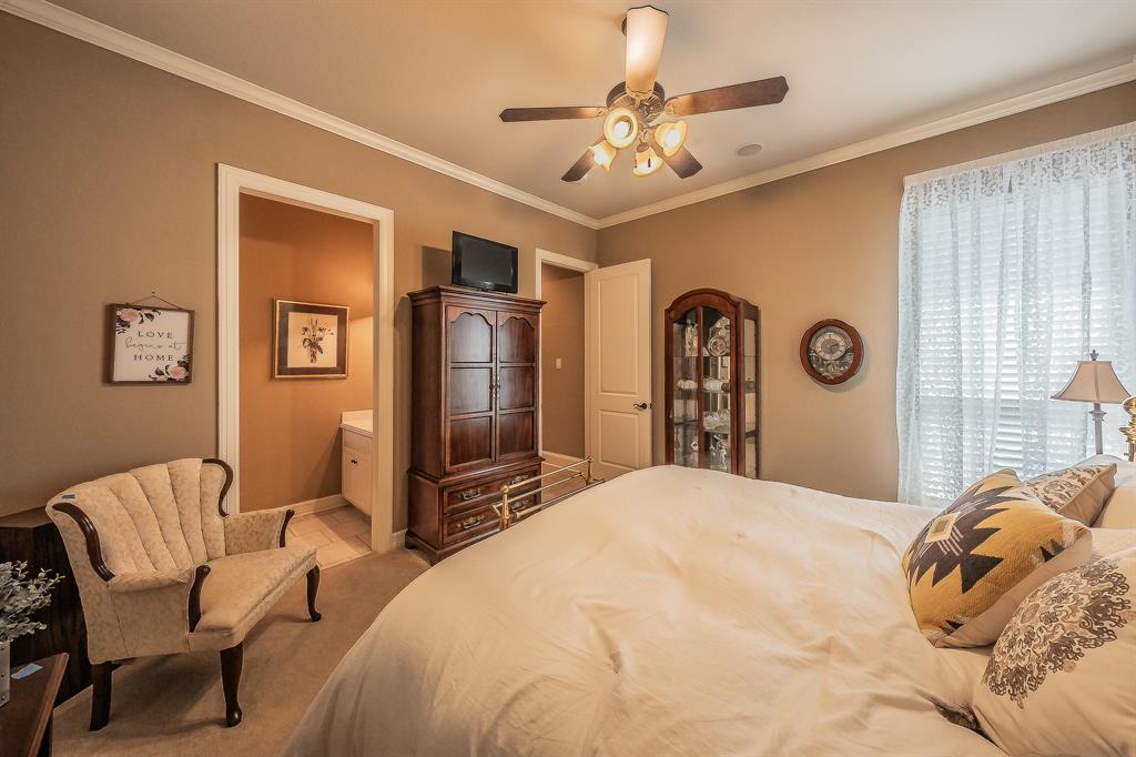 2726 Country Club Road Pantego, TX 76013 - Photo 18 of 26 a bedroom with a large bed and a chandelier