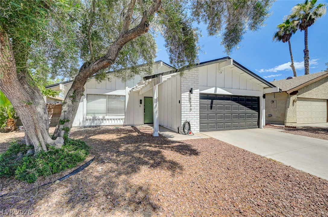 4840 Summerhill Road Las Vegas, NV 89121 - Photo 3 of 56 White siding and a striking dark garage door create a compelling facade.