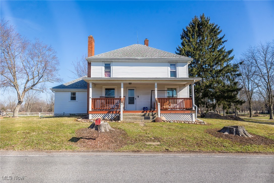5905 Buffham Road Seville, OH 44273 - Photo 1 of 50 View of front of home with covered porch, a front yard, a shingled roof, and a chimney