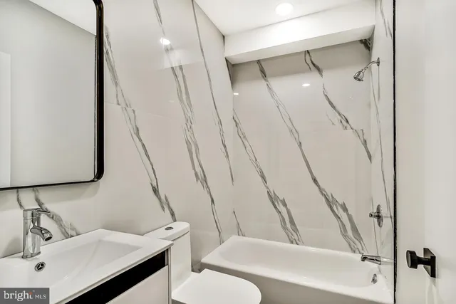 a bathroom with a sink a toilet and mirror