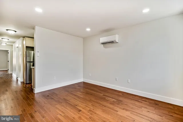 a view of an empty room with wooden floor
