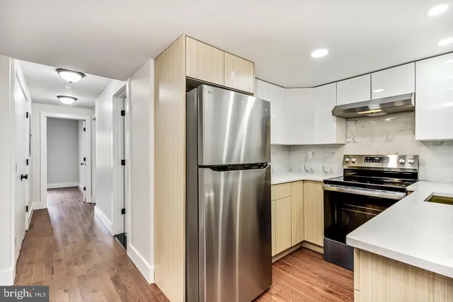 a kitchen with a sink a refrigerator and cabinets