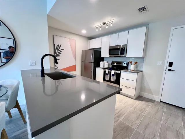 a large kitchen with stainless steel appliances granite countertop a stove a sink dishwasher and a refrigerator