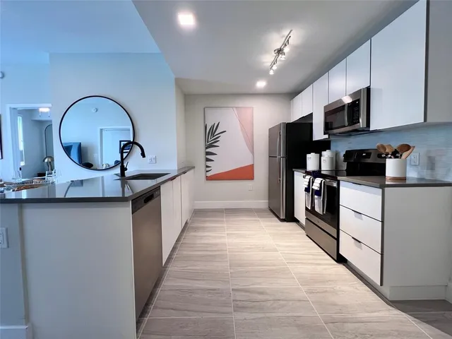 a kitchen with stainless steel appliances granite countertop a sink and cabinets