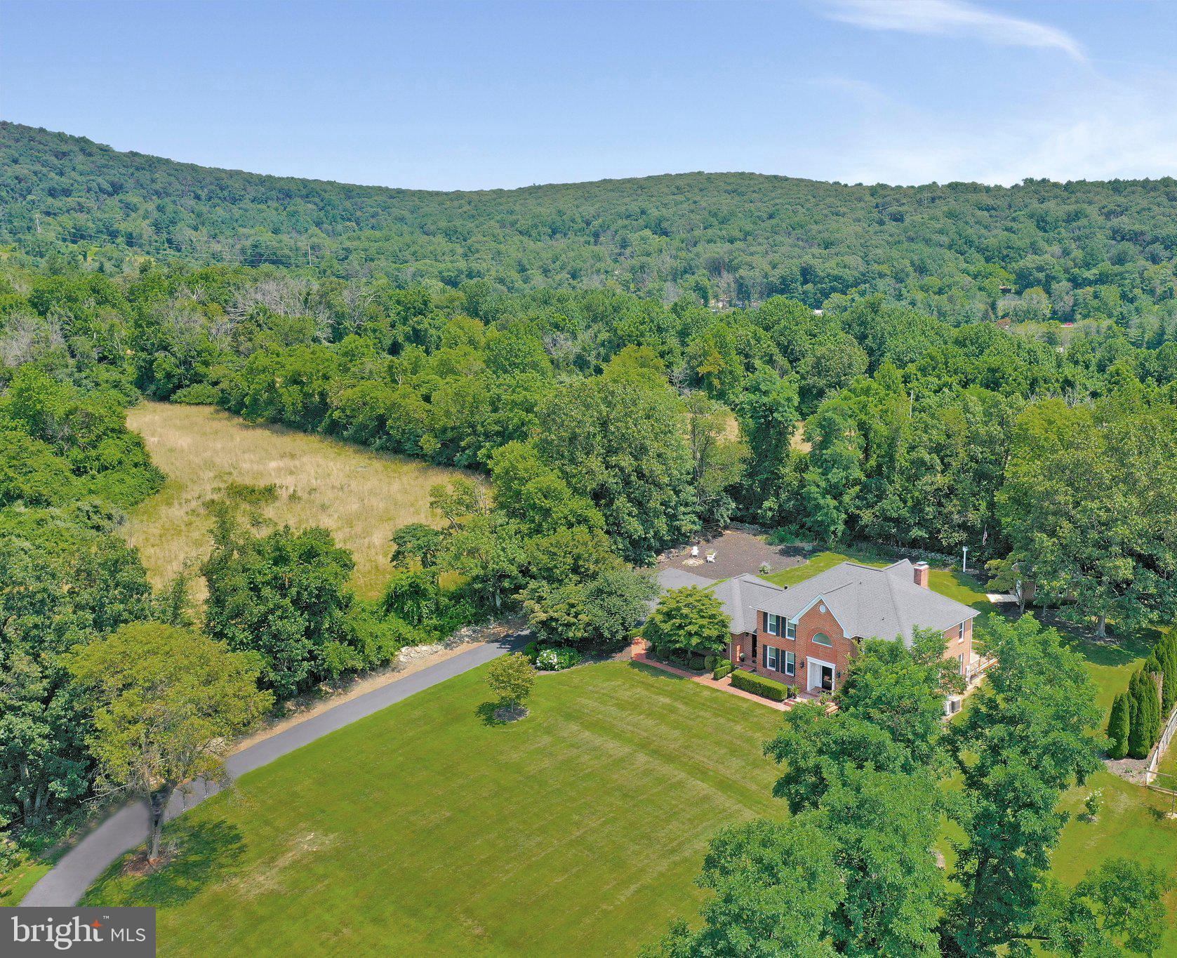 7845 Ridge Road Frederick, MD 21702 - Photo 3 of 67 a view of a lush green outdoor space with a swimming pool and valleys in the background