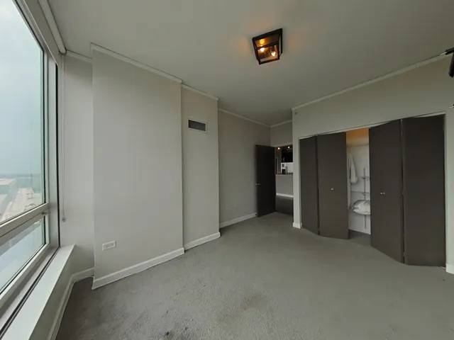 an empty room with closet and a hallway
