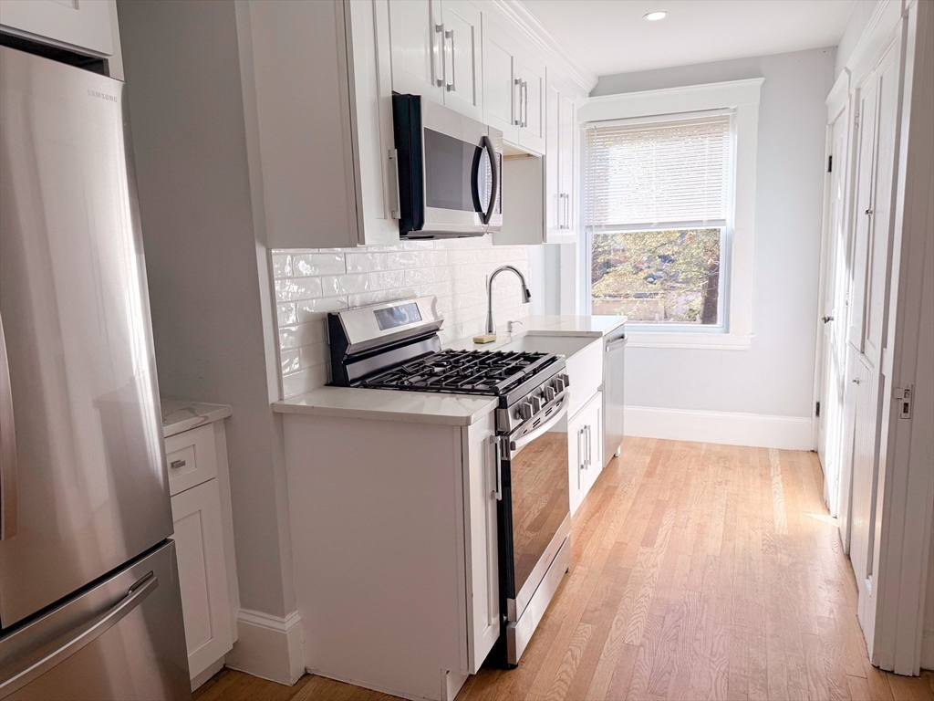 39 Pond Street, Unit 2 Framingham, MA 01702 - Photo 11 of 18 a kitchen with stainless steel appliances a stove a sink and a refrigerator