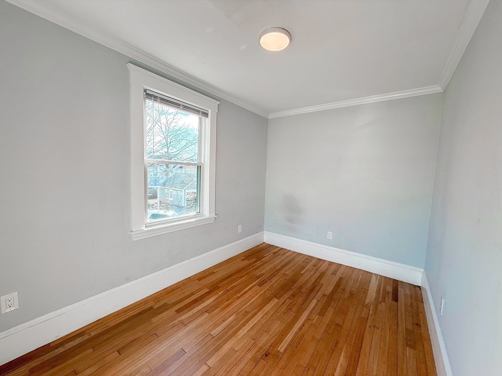 39 Pond Street, Unit 2 Framingham, MA 01702 - Photo 14 of 18 an empty room with wooden floor and windows