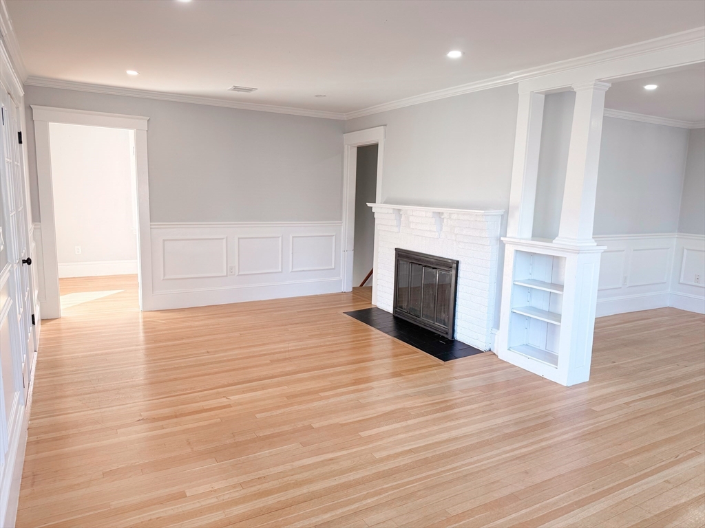 39 Pond Street, Unit 2 Framingham, MA 01702 - Photo 3 of 18 a view of a livingroom with wooden floor and a fireplace