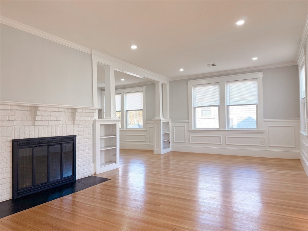 39 Pond Street, Unit 2 Framingham, MA 01702 - Photo 7 of 18 a view of empty room with wooden floor and fireplace